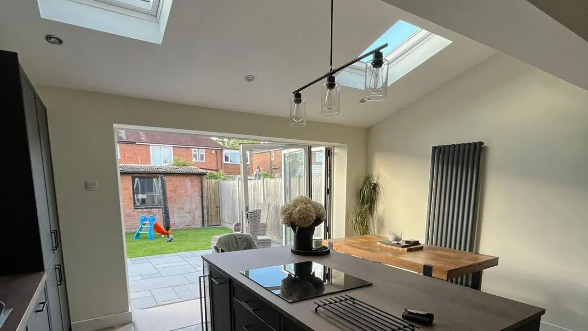 A kitchen extension by JCT Building, with roof windows and bifold doors onto the garden